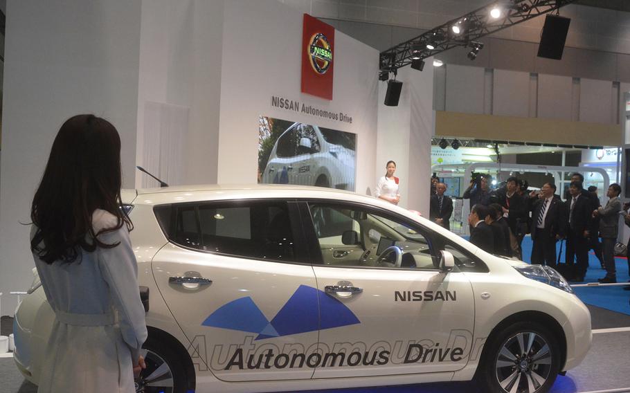 Nissan officials discuss their driverless concept car at the 2013 Tokyo Motor Show.