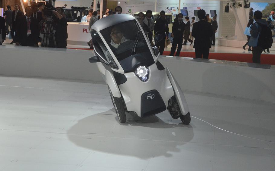 A driver takes a spin in a Toyota 3-wheel electric concept car.