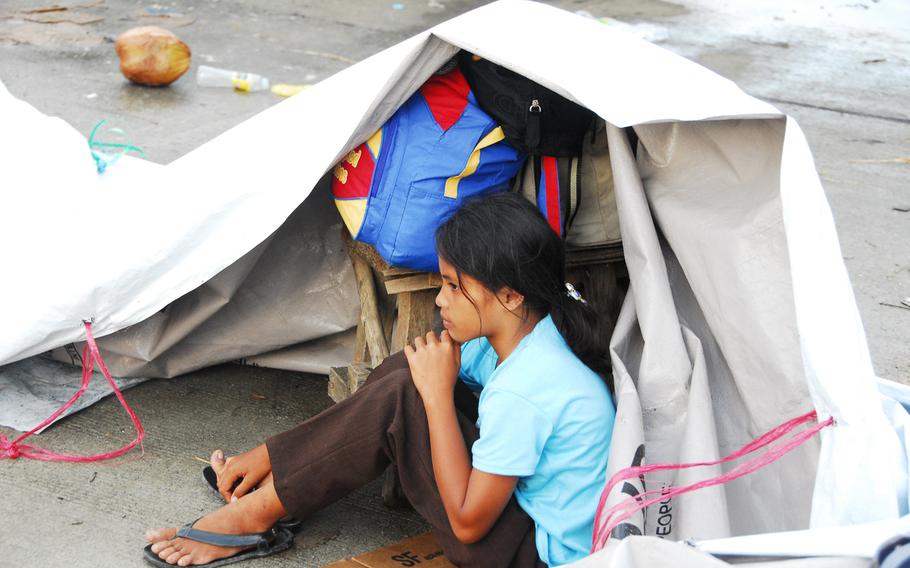 A young girl waits for evacuation at Guiuan Airport on Nov. 22, 2013. Two U.S. Navy ships arrived in the area on Friday to take over typhoon relief operations from U.S. Marines who have been in the Philippines for more than a week.