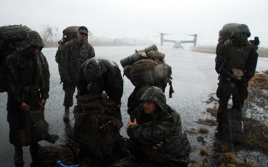 U.S. Marines wait in the rain at the Guiuan airport in the Philippines on Nov. 22, 2013. After more than a week on the ground helping Typhoon Haiyan victims, the Marines are packing up and heading back to Okinawa.