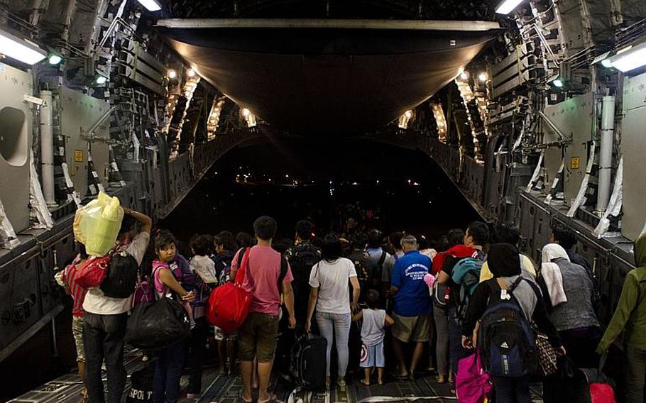 A team of relief workers from multiple nations welcome nearly 500 victims of Super Typhoon Haiyan to Villamore Airbase in Manila, Philippines after they were evacuated from Tacloban Airport, Tacloban, Philippines on Nov. 22, 2013.