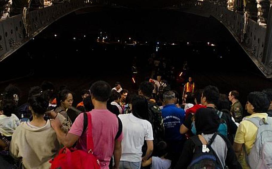 A team of relief workers from multiple nations welcome nearly 500 victims of Super Typhoon Haiyan to Villamore Airbase in Manila, Philippines after they were evacuated from Tacloban Airport, Tacloban, Philippines on Nov. 22, 2013.