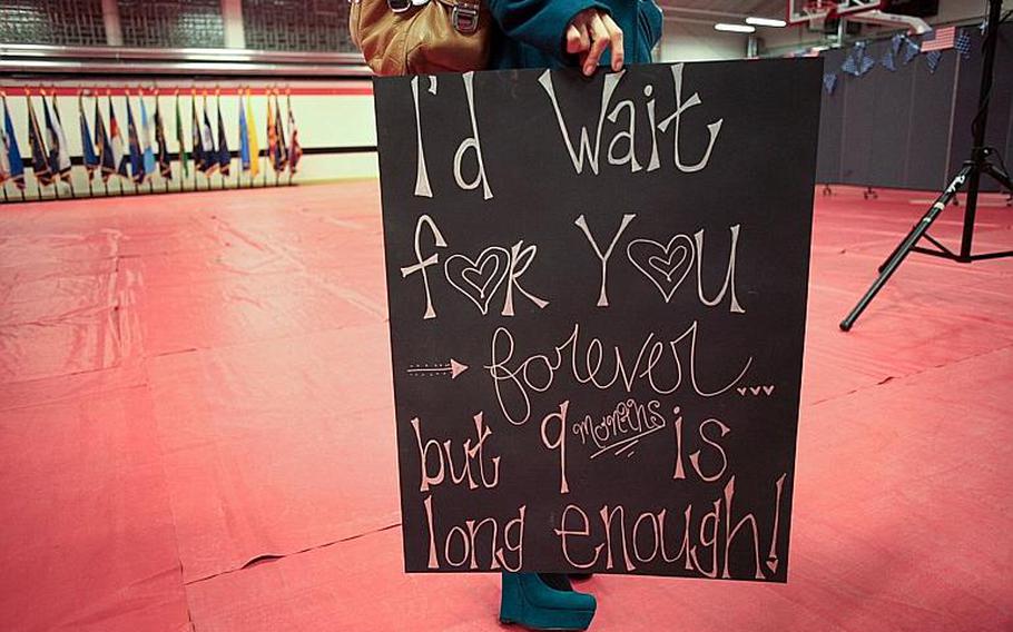 The wife of a 39th Transportation Battalion (Movement Control) soldier holds a sign welcoming him home Saturday, Nov. 23, at Kleber Kaserne in Kaiserslautern, Germany. Matt Millham/Stars and Stripes