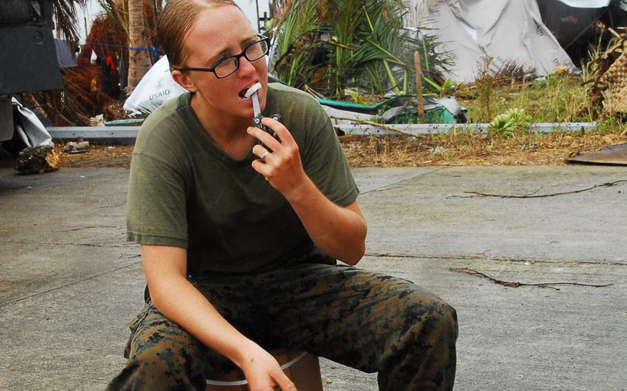 Marine Cpl. Kaycee Morales, 22, of Las Cruces, N.M., eats a coconut during typhoon relief operations in The Philippines on Friday, Nov. 22, 2013.