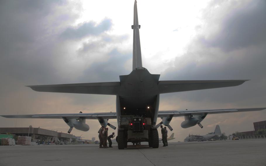 A U.S Marine Corps Millennium Military Vehicle, operated by Lance Cpl. Elijah L. Gates, loads high-energy biscuits into a Japanese C-130H Super Hercules on Nov. 22, 2013. The cargo was headed to Tacloban, one of the regions hardest hit by Typhoon Haiyan.