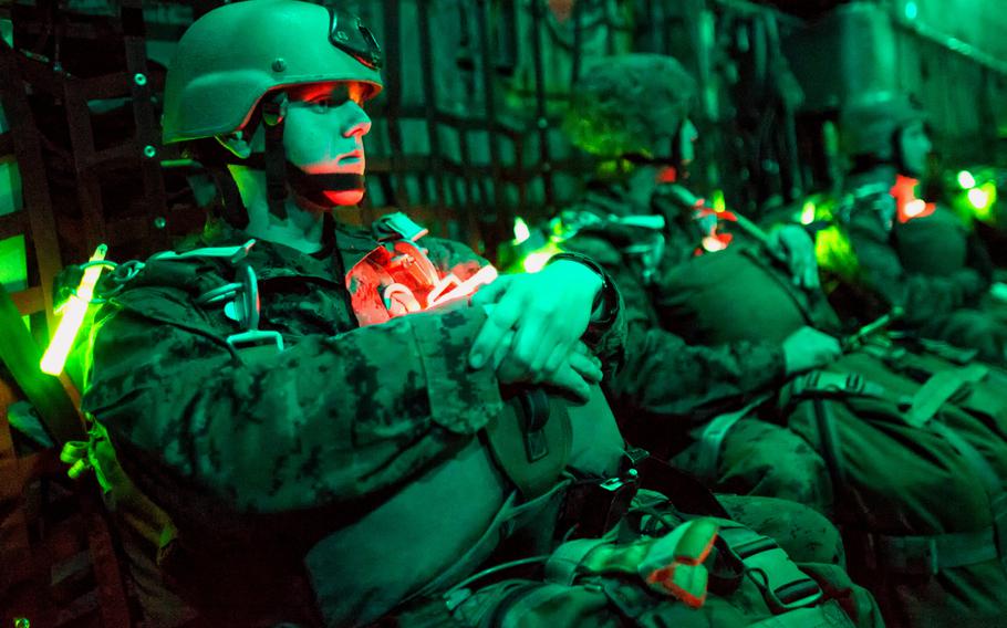 Marines with the 3rd Reconnaissance Battalion, 3rd Marine Division, wait on a C-130 Hercules prior to taking part in night jump training over Yokota Air Base, Japan, Nov. 21, 2013. The training not only allowed the Marines to practice jumping, but it also allowed the Yokota aircrews to practice flight tactics and timed-package drops.