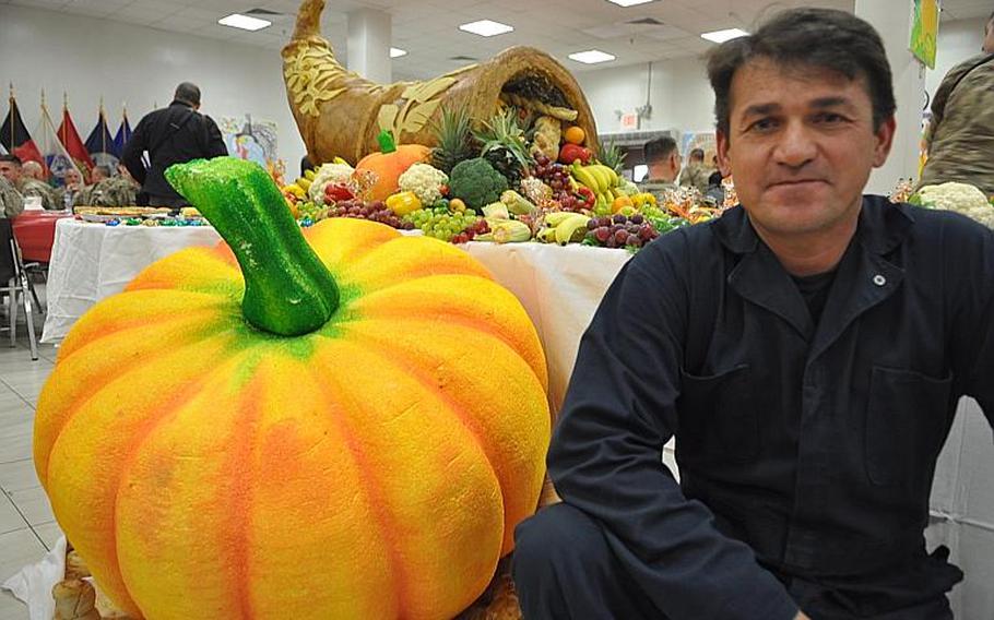 At New Kabul Compound, giant styrofoam gourds and an overflowing cornucopia decked out the dessert table. They were constructed by two Afghan contractors, one of whom, named Sultan, is pictured here. The carpenters stacked dozens of layers of packaging foam, then carved, sanded and painted them.
