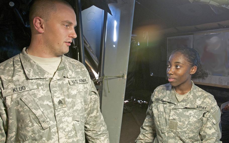 Pvt. Anika Degraff, a fire direction specialist with Headquarters and Headquarters Battery, 2nd Battalion, 20th Field Artillery Regiment, Task Force Pegasus Fires at Fort Hood, Texas, speaks with her supervisor Nov. 19 inside 2-20th FAR command tent during a validation exercise. Degraff is one of the first female fire direction specialists to assigned to 2-20th FAR.