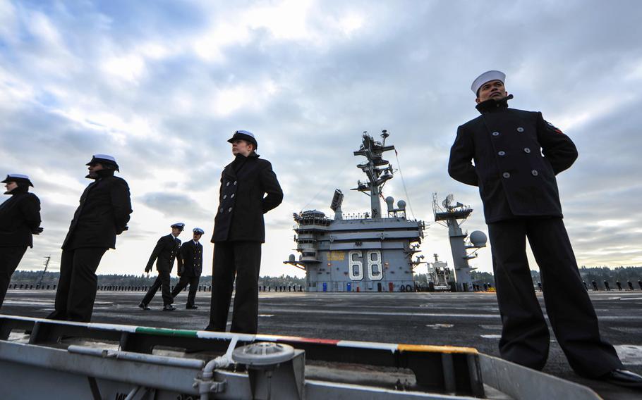 Sailors man the rails as the aircraft carrier USS Nimitz arrives at homeport at Naval Station Everett, Wash., on Dec. 16, 2013.
