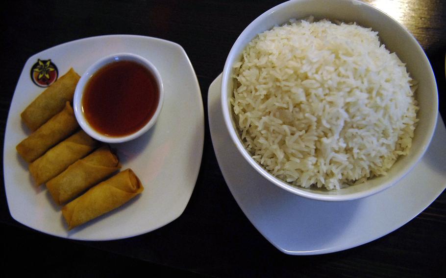 Vegetarian spring rolls sit next to a steaming bowl of rice at Zimtblüte, an Asian food restaurant in Einsiedlerhof, Germany.