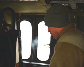 Spc. Morgan Frisk's breath freezes while he runs maintenance tests on his flight team's Blackhawk. Snow, rain, and low cloud cover kept most helicopters grounded for about a week at Kandahar Air Field, in a desert where temperatures climb above 130 Farenheit in the summer.