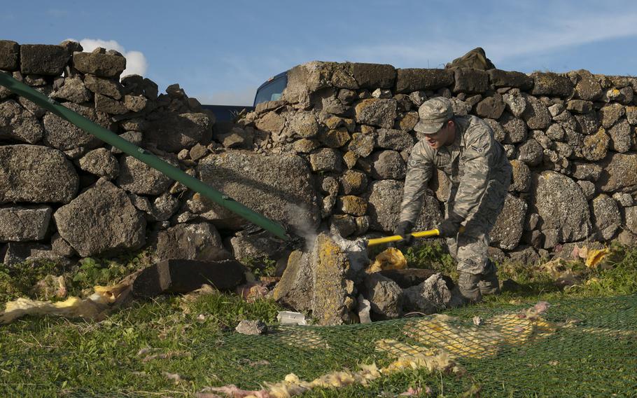 U.S. Air Force Airman 1st Class Daniel Gosselin, 65th Civil Engineer Squadron power production technician, breaks up concrete on Saturday, Feb. 15, 2014, at Lajes Field, Azores. Lajes Field was hit with a low-pressure weather system Feb. 13, and strong winds caused damage to base facilities and military family housing.
Paul Villanueva II/U.S. Air Force