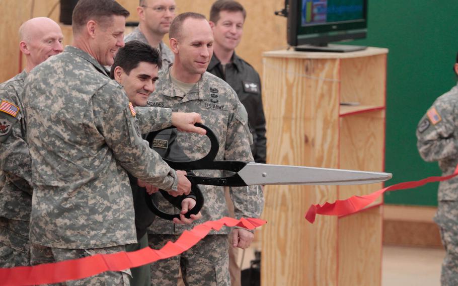 Maj. Gen. John O'Connor, commander of the 21st Theater Sustainment Command, left, and Maj. Gen. Laurian Anastasof, chief of the Romanian air force staff, cut the ribbon Friday, Feb. 28, 2014, at the new U.S. transit center at Mihail Kogalniceanu Air Base near Constanta, Romania.