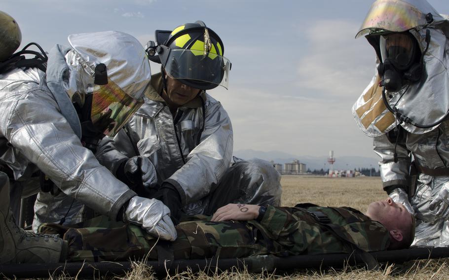 Firemen from the Yokota Fire Department tend to the simulated injuries of an airman assigned to the 374th Airlift during the Samurai Readiness Insepction at Yokota Air Base March 3, 2014.