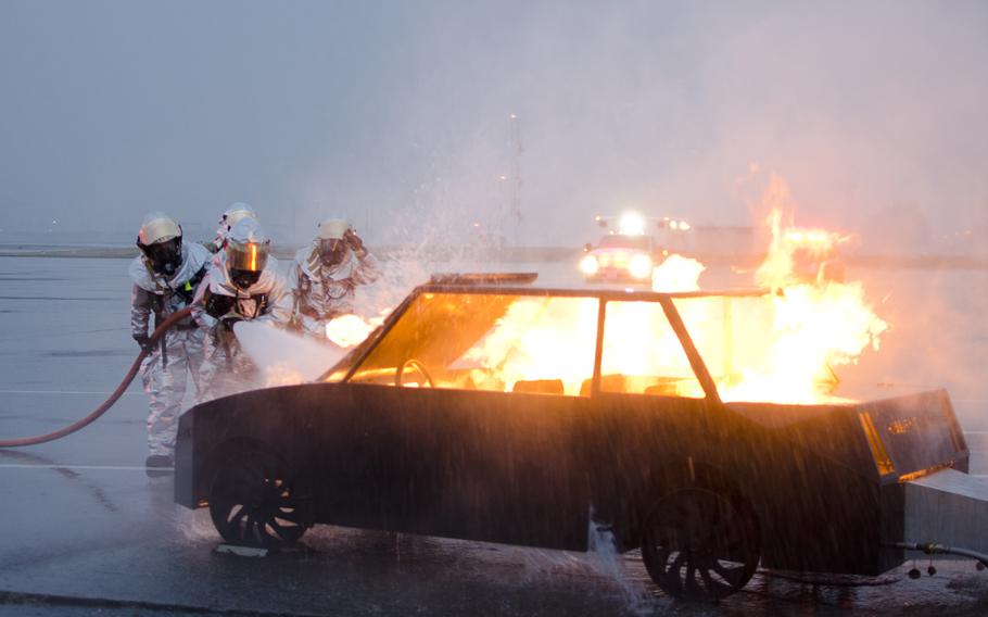 Firemen from the Yokota Fire Department fight a fire from a simulted Vehicle Borne Improvised Explosive Device during the Samurai Readiness Inspection at Yokota Air Base on March 4, 2014.