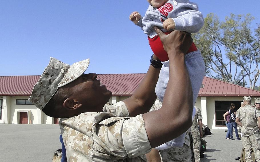 Cpl. Jason Singleton hoists his son, Cameron, in the air as he prepares to leave Camp Pendleton, Calif., for a six-month deployment to Australia. Cameron was born just before Singleton returned from his last deployment and will turn one next weekend.