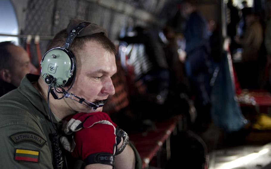 A Lithuanian servicemember sits in the back of a C-27 flying toward Sweden as part of a training exercise with NATO on Tuesday, April 1, 2014. The training gave fighter pilots a chance to practice intercepting a plane that ceased communicating with officials on the ground.