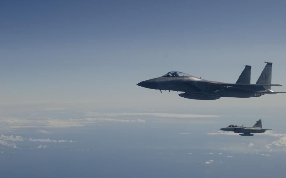 An F-15C Eagle, foreground, stationed at Siauliai air base, Lithuania, and a Swedish JAS-39 Gripen Fighter fly next to a Lithuanian C-27 that is headed for a training event over the Baltic Sea on Tuesday, April 1, 2014. The C-27 was simulating a communications failure and the fighters intercepted the plane.