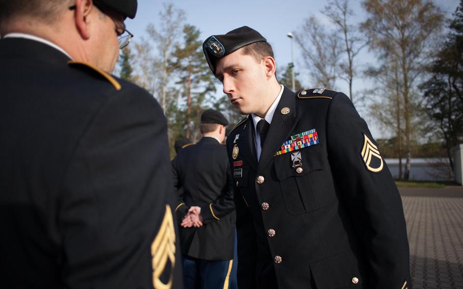 Staff Sgt. Miachael Ostrawski inspects the awards and decorations on Staff Sgt. Anthony Caracausa's uniform Thursday, April 3, 2014, during an inspection that was part of the 21st Theater Sustainment Command's "Millrinder Time," an activity similar to the Army's payday activities of another era.