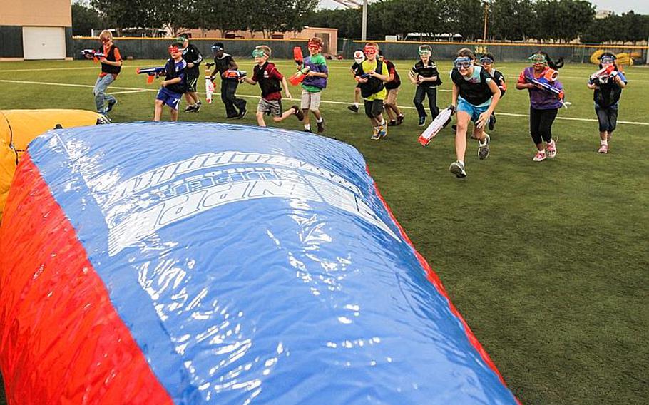 Kids charge the field as they take on about 15 U.S. Marines in a game of Nerf tag at Naval Support Activity Bahrain April 4, 2014.