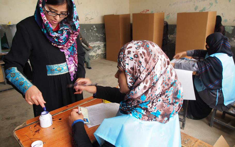 A woman prepares to vote at a polling station in eastern Kabul on Saturday, April 5, 2014, during Afghanistan's presidential election.