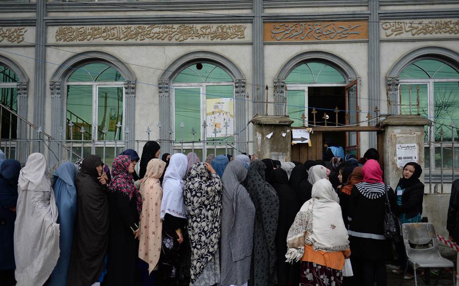 Afghan women line up outside a polling station at a mosque in Kabul on Saturday, April 5, 2014. Long lines of Afghans, including women, often stretched for blocks early on election day.