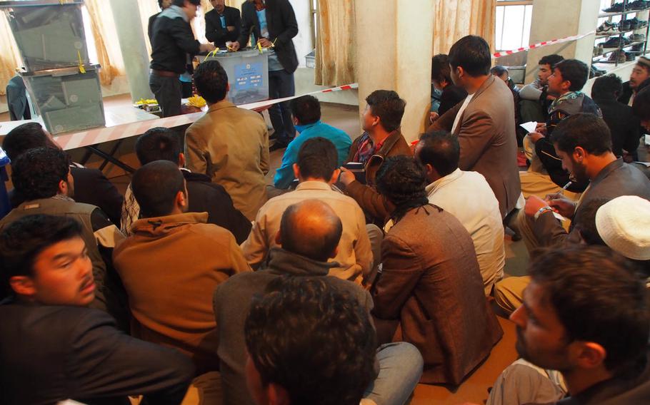 Election officials prepare to count ballots in front of a group of observers at a polling station in Kabul on Saturday, April 5, 2014, following the country's historic presidential vote.