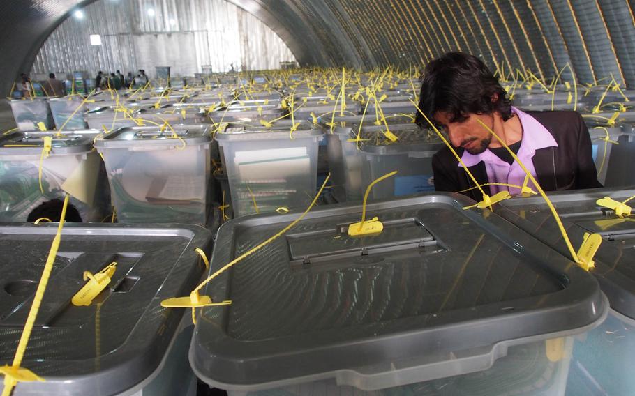 A man inspects ballot boxes at a storage facility at Afghanistan's Independent Election Commission on Sunday, April 6, 2014, a day after the country's historic presidential vote. The winner won't be know for some time, but whoever prevails will have the task of governing a country beset by corruption and with an entrenched insurgency.