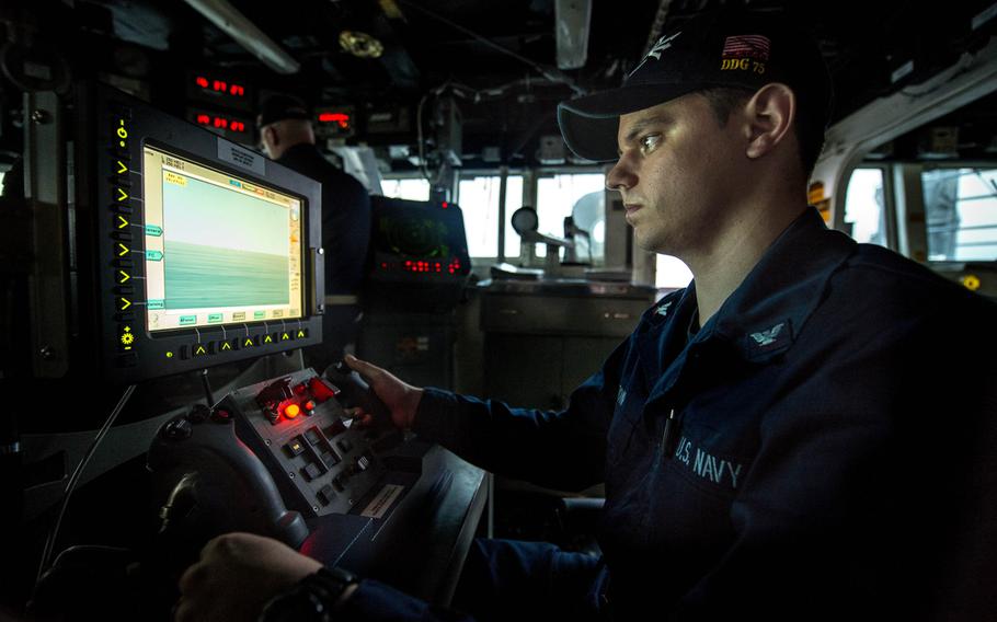 Fire Controlman 3rd Class Thomas Colton mans a Mark 38 25 mm machine gun console on the bridge of the Arleigh Burke-class guided-missile destroyer USS Donald Cook, April 3, 2014. The Cook is the third warship headed to the Black Sea in three months amid tensions over Russia's annexation of Ukraine's Crimea Peninsula.