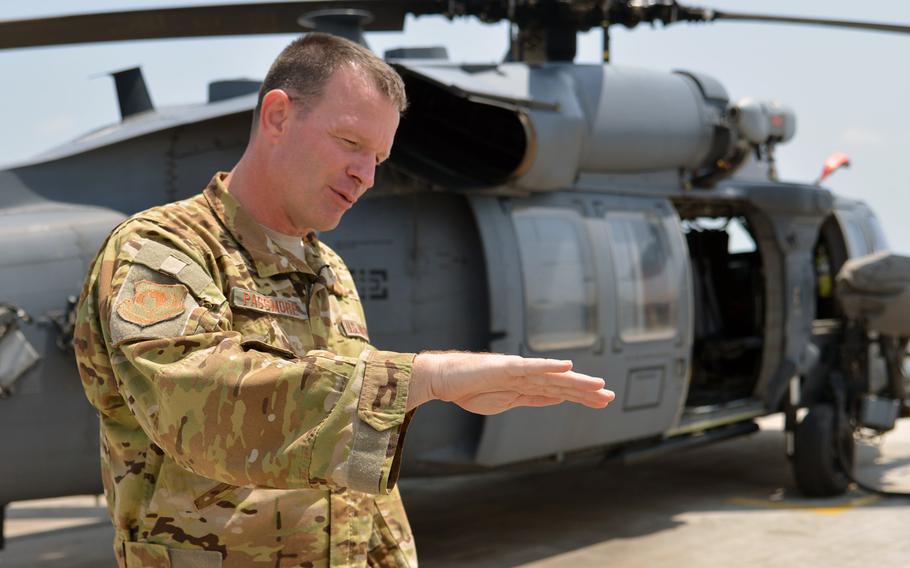 Col. Kelly Passmore, 449th Air Expeditionary Group commander at Camp Lemonnier, Djibouti, talks about search and rescue missions while standing in front of one of his unit's HH60 Pave Hawk helicopters, Tuesday, April 1, 2014.