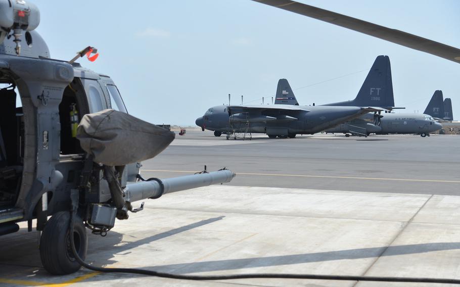 An HH-60 Pave Hawk helicopter, left, and HC-130 and C-130 aircraft sit on the tarmac at Camp Lemonnier, Djibouti, Tuesday, April 1, 2014. The 449th Air Expeditionary Group deployed to Djibouti uses the HH-60s and HC-130s for airlift and personnel recovery missions.