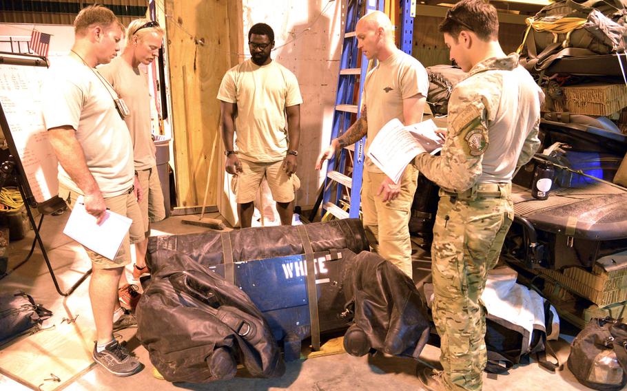 Pararescuemen of the 82nd Expeditionary Rescue Squadron at Camp Lemonnier, Djibouti, discuss the best way to prepare equipment for a mission, Thursday, April 3, 2014.