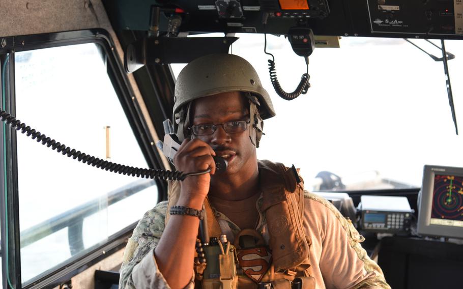 Petty Officer 2nd Class Javan Wells, the patrol leader, talks to the other vessels of Coastal Riverine Squadron-1 Forward Wave 2, as they patrol the port of Djibouti.