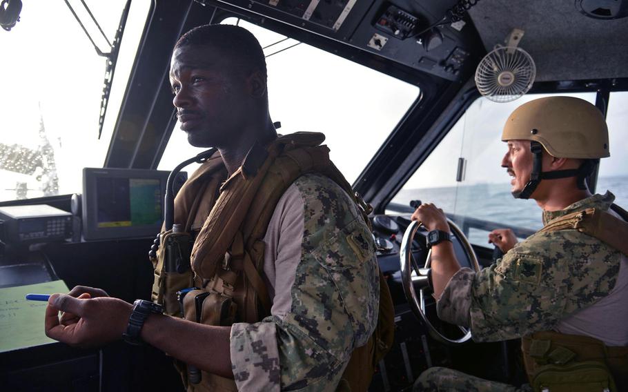 Petty Officer 2nd Class Javan Wells, left, the patrol leader, and Petty Officer 2nd Class Eric Lee go through a search and rescue maneuver while their unit, the Coastal Riverine Squadron-1 Forward Wave 2 patrol the port of Djibouti.