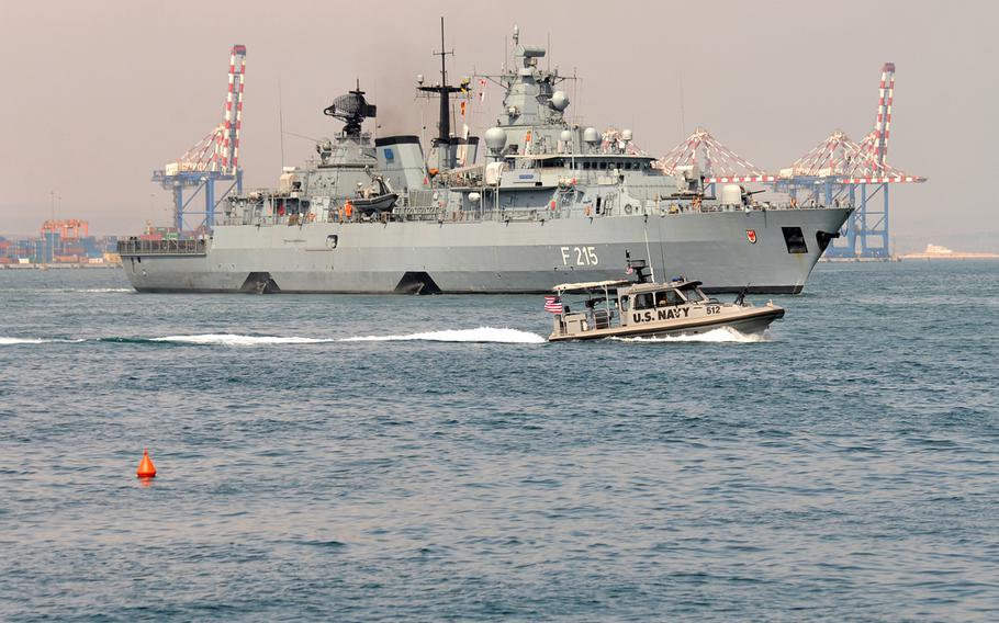 A vessel of Coastal Riverine Squadron-1 Forward Wave 2 passes the German frigate Brandenburg while patrolling in Djibouti port.