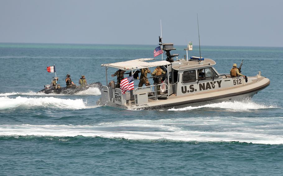 A U.S. Navy Sea Ark of Coastal Riverine Squadron-1 Forward Wave 2 forces away a French motor boat during training in the Djibouti port. The Navy?s Coastal Riverine Squadrons, formed soon after the 2000 terrorist attack on the USS Cole in Yemen, provide security for Navy ships navigating through dangerous waters around the world.