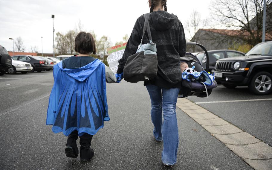 From left to right, Jaden Monteleone, 5, Tiana Musson and seven-month-old Emrick Monteleone walk to gym on Rose Barracks, Germany where Jeremy Monteleone and his unit will arrive for a brief ceremony after a seven-month deployment to Afghanistan, April 8, 2014.