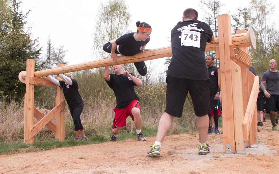 Teamwork helps a runner make it over a rolling log obstacle at the Grafenwöhr Rugged Terrain Obstacle Course, April 12, 2014.