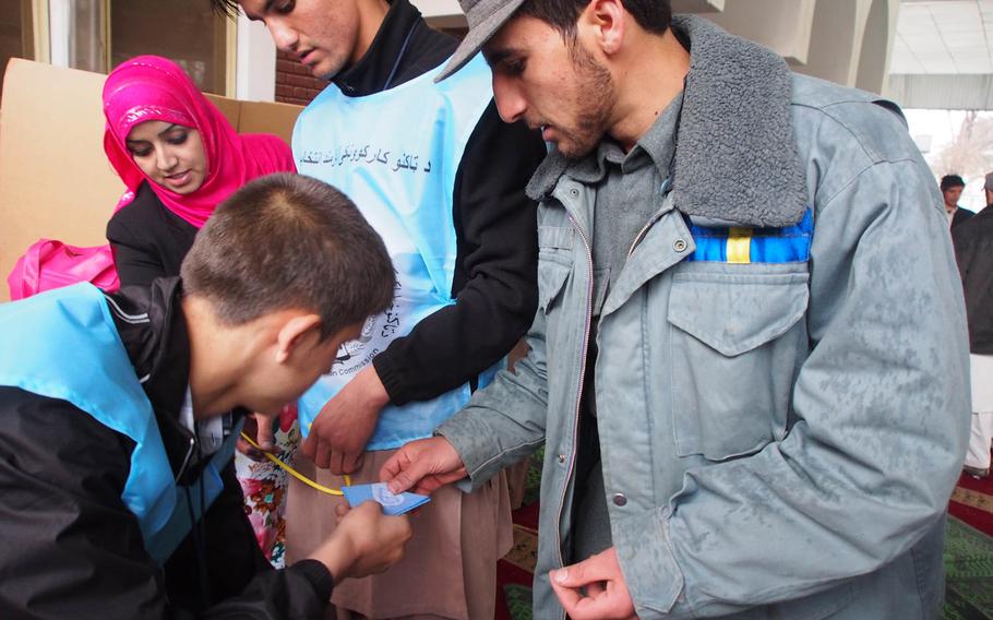 An Afghan National Police officer votes during Afghanistan's historic presidential election April 5, 2014. Since election day, election monitoring organizations charge that independent observers have largely been kept in the dark about vote counting and fraud decisions. 