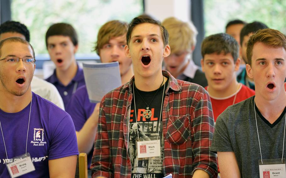 Vilseck's Kraig Sumpter and Mark Clifton and Rota's Grant Wilholt, from left, rehearse Handel's "Hallelujah Chorus" with the choir at the Department of Defense Dependents Schools-Europe Honors Music Festival, Tuesday, April 15, 2014. Nearly 160 students from DODDS-Europe high schools attended the annual festival.