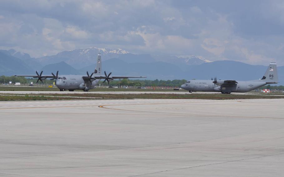 Two C-130 cargo planes from Ramstein Air Base, loaded with servicemembers from the 173rd Infantry Brigade Combat Team based in Vicenza, Italy, taxi across the runway prior to departing Aviano Air Base, Italy for Poland on Wednesday, April 23, 2014.