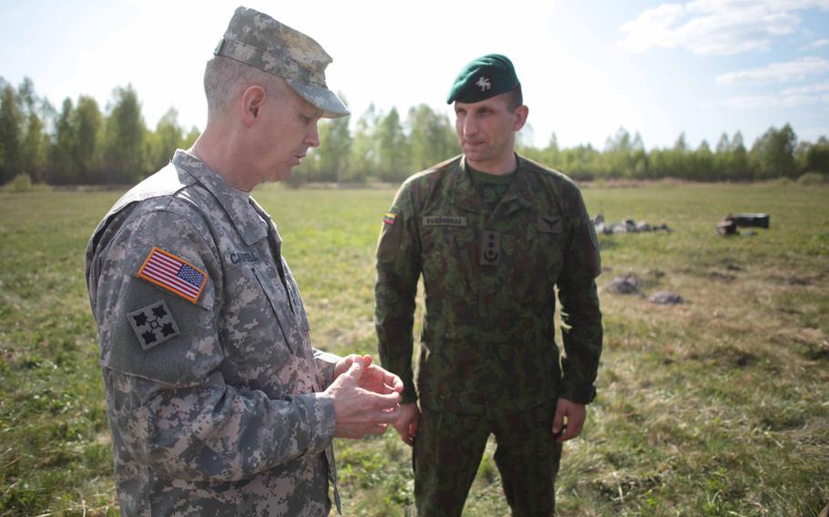 Lt. Gen. Donald Campbell, commander of U.S. Army Europe, speaks with Col. Raimundas Vaiksnoras, commander of the Lithuanian "Iron Wolf" motorized infantry brigade. at Lithuania's Rukla Training Area.