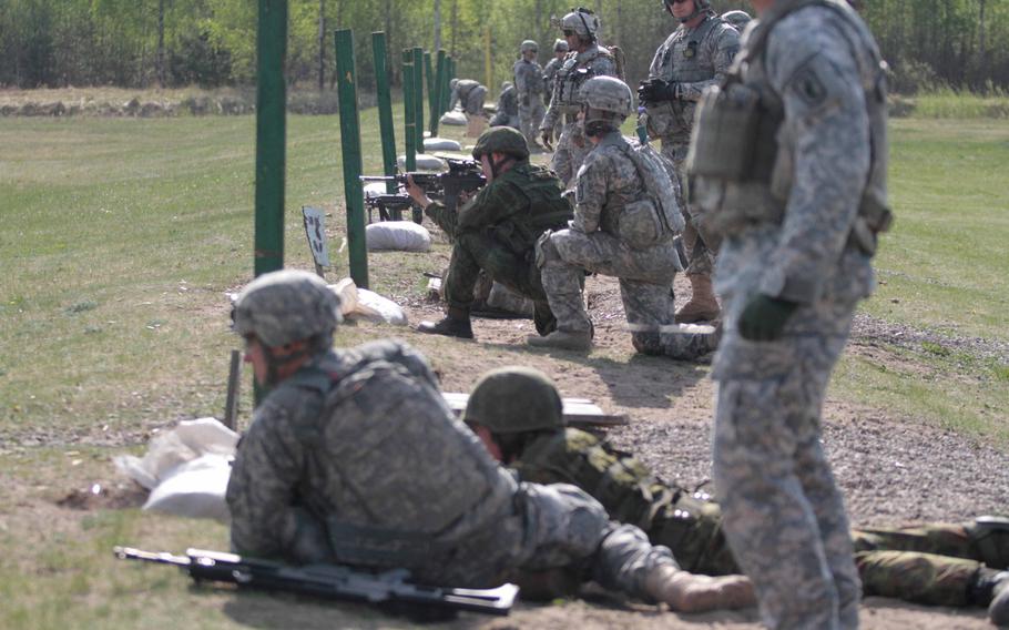 U.S. and Lithuanian troops fire each other's weapons Tuesday, April 29, 2014, at a military training area in Lithuania during joint training.