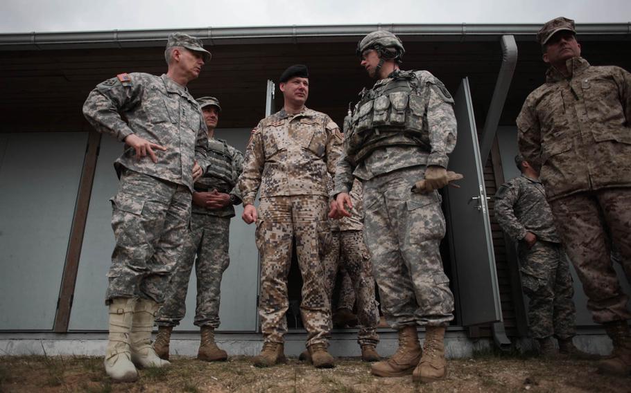 Lt. Gen. Donald Campbell Jr., left, the commander of U.S. Army Europe, speaks Wednesday, April 30, 2014, with the commander of an American rifle company and the commander of a Latvian army brigade, who are conducting joint training exercises outside of Riga, Latvia, which is roughly 120 miles from the Russian border.