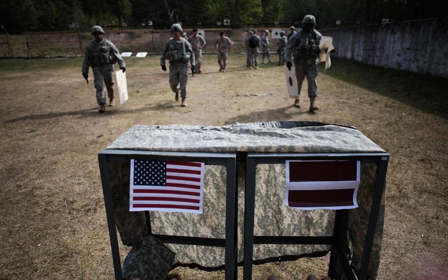 An American and a Latvian flag are taped to a table at a pistol range Wednesday, April 30, 2014, in Adazi, Latvia, where U.S. and Latvian soldiers are conducting joint training.