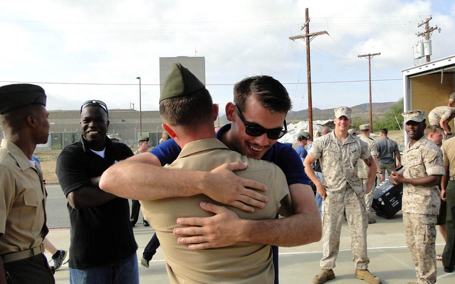 Cpl. Jeremy Schacht hugs a fellow Marine on Friday, May 23, 2014, at Camp Pendleton, California, before leaving for a deployment to Afghanistan. This is Schacht's second deployment there; he said he extended his contract so he could deploy again with the new Marines in his unit.