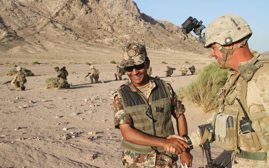U.S. Marine Cpl. Kyle Wellmon shakes hands with a Jordanian soldier during a joint reconnaissance patrol June 12, 2013, in Al Quweira, Jordan. The patrol was carried out with Marines from the 26th Marine Expeditionary Unit during last year's Eager Lion exercise