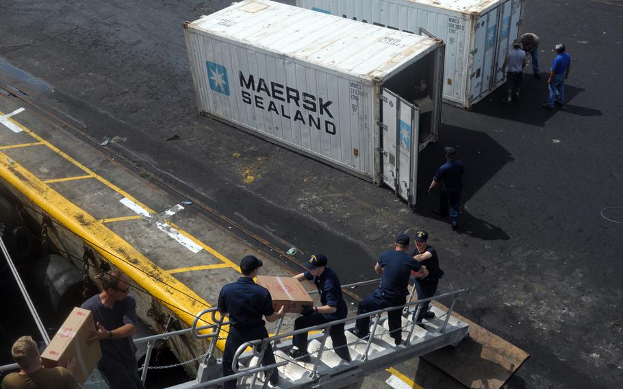 Sailors and civilian mariners with the Navy catamaran USNS Spearhead unload a cargo container of food provisions before pushing off from Lagos, Nigeria, on April 17, 2014. With too few warships to meet the demands of combatant commanders, the Navy is increasingly turning to civilian and contract mariners with the Military Sealift Command to accomplish its missions.