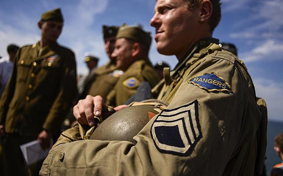 World War II Ranger Regiment re-enactors wait to get autographs from WWII Ranger veterans after the 70th anniversary D-Day commemoration honoring the regiment's achievements at Pointe du Hoc, France, Saturday, June 7, 2014.