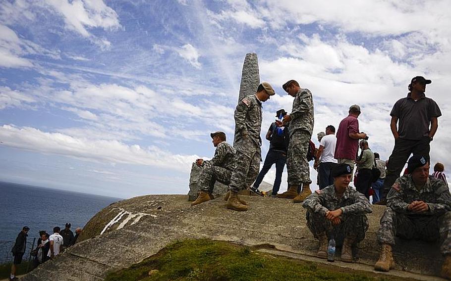 Soldiers with the Ranger Regiment and 1st Infantry Division wait along with visitors prior to a 70th anniversary D-Day commemoration at the Ranger Regiment Memorial at Pointe du Hoc, France, Saturday, June 7, 2014.